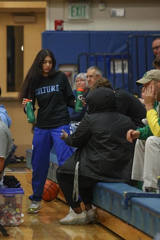 Sandhu handing out waters at a basketball game. 