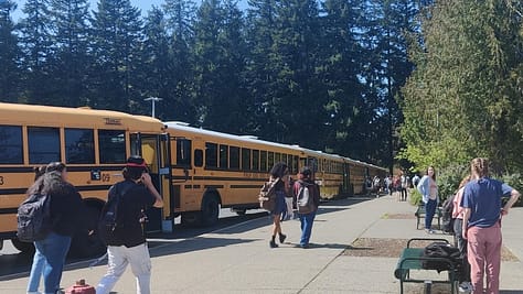 Students board a line of busses after school